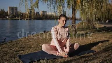 现代大都市<strong>长廊</strong>上的瑜伽.. 穿着<strong>运动</strong>服的女孩在河上瑜伽垫上。